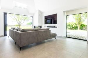 a living room with a couch and a tv at The Studio at Cherry Tree in Natland