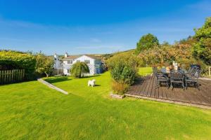 a dog sitting in the yard of a house at CROYDE MEADOWBANK 4 Bedrooms in Croyde
