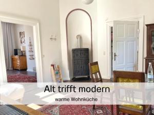 ein Wohnzimmer mit einem Tisch und einem Spiegel in der Unterkunft FeWo "Ebbe" im historischen Denkmal, ruhig & modern mit Stil, Kunst und großem Garten, hochwertiger Ausstattung & zentraler Lage in Esens- 3km zur Nordsee, alles fußläufig erreichbar - ideal für Paare oder kleine Familien in Esens + 37 Fotos