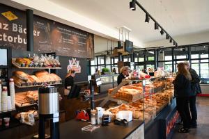 a group of people standing at a counter in a bakery at Tiny House Pioneer 5 - Green Tiny Spot Schillig in Wangerland