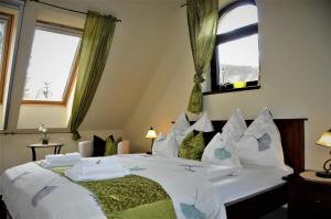 a bedroom with a large white bed with windows at Brauer Panzió in Mecseknádasd +51 photos