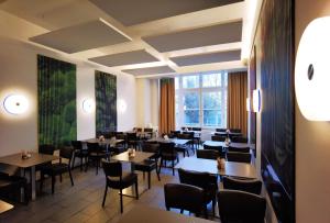 a restaurant with tables and chairs in a room at Arthotel Munich in Munich