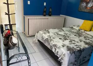a bedroom with a bed and a blue wall at Flat em Gravatá in Gravatá
