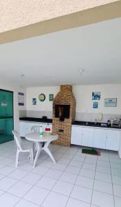 a kitchen with a table and a brick oven at Flat em Gravatá in Gravatá