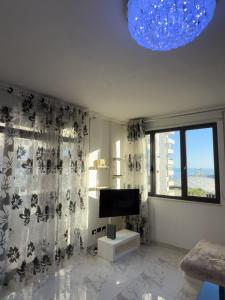 a living room with a television and a window at Sea View Apartment in Durrës
