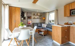 a small kitchen and living room with a table and chairs at Camping le Héron in Dolus-d'Oléron