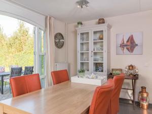 a dining room with a wooden table and orange chairs at Christoffellaan 101 in Brouwershaven