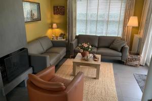 a living room with a couch and a tv at Christoffellaan 101 in Brouwershaven