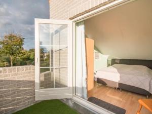a bedroom with a bed and a sliding glass door at Christoffellaan 101 in Brouwershaven