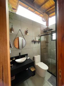 a bathroom with a toilet and a sink and a shower at Chalé Alecrim in Córrego do Bom Jesus