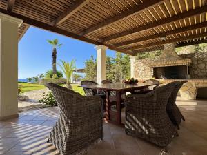 a patio with a table and chairs and a fireplace at Villa Odysseus Spartia Kefalonia in Spartià