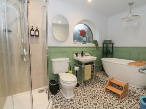 a bathroom with a tub and a toilet and a sink at Moorview in Holmfirth +19 photos
