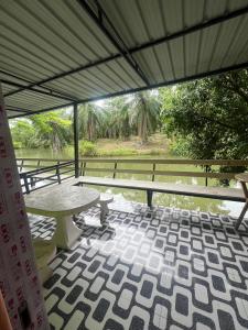 a patio with a table and a view of the water at Martin, Local Guide & Camping in Ban Phang Kan Nua