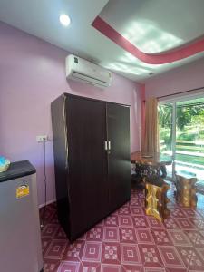 a living room with a black cabinet and a table at Martin, Local Guide & Camping in Ban Phang Kan Nua