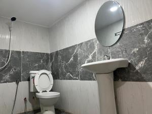 a bathroom with a sink and a toilet and a mirror at Martin, Local Guide & Camping in Ban Phang Kan Nua +1 photo