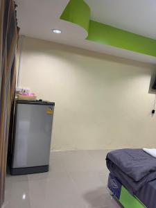 a room with a small refrigerator and a green ceiling at Martin, Local Guide & Camping in Ban Phang Kan Nua