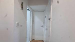 a hallway with white walls and a door at Extra Large One Bedroom Flat with Parking in London