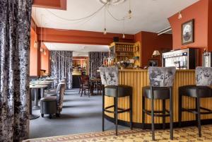 a restaurant with a bar with chairs and tables at Sure Hotel by Best Western Argentan in Argentan