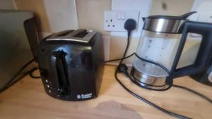a toaster and a coffee maker on a counter at Extra Large One Bedroom Flat with Parking in London