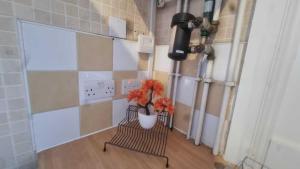 a room with two benches and a vase with flowers at Extra Large One Bedroom Flat with Parking in London +22 photos