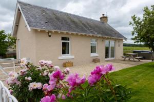 a house with pink flowers in front of it at Bachilton Farm Holidays in Perth