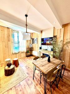 a living room with a wooden table and chairs at Le Safari - Montélimar in Montélimar