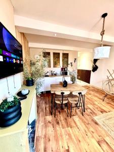 a living room with a table and chairs and a kitchen at Le Safari - Montélimar in Montélimar