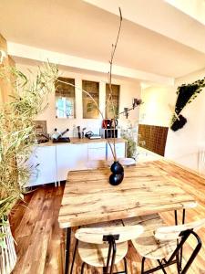 a kitchen with a wooden table with two chairs at Le Safari - Montélimar in Montélimar +7 photos