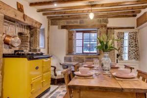 a kitchen with a wooden table and yellow appliances at The Cow House - In the heart of Whitby in Whitby