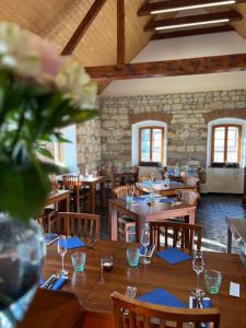 a restaurant with wooden tables with blue napkins and flowers at Apartmán typu Loft in Hořovičky