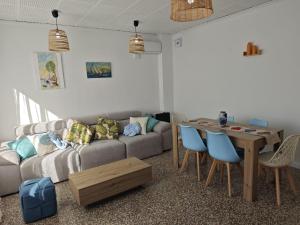 ein Wohnzimmer mit Sofa und Tisch in der Unterkunft SeaSuites Blue-Ático con terraza chillout cerca del mar en Cullera in Mareny de San Lorenzo + 27 Fotos