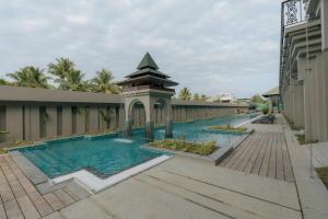 a swimming pool with a gazebo next to a building at Seashell Samssara Havelock in Havelock Island