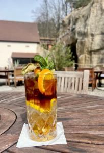 a glass of iced tea with oranges on a wooden table at Apartmán typu Loft in Hořovičky