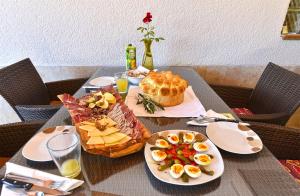 a table with plates of food and a basket of fruit at Room with pool 2371 in Medulin