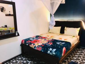 a bed in a room with a mirror at Diyana Cottage in Sigiriya