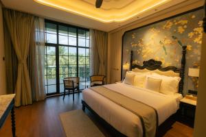 a bedroom with a large bed with a painting on the wall at Seashell Samssara Havelock in Havelock Island +68 photos