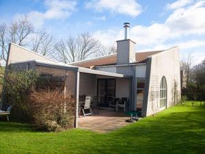 a brick house with a patio in a yard at Christoffellaan 57 in Brouwershaven