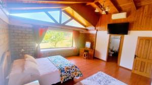 a bedroom with a bed and a large window at Casa Quinta el Labrador Renaico in Estación Roblería