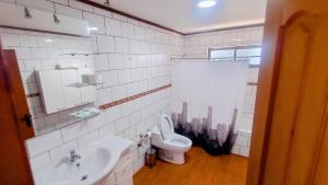 a white bathroom with a sink and a toilet at Casa Quinta el Labrador Renaico in Estación Roblería +17 photos