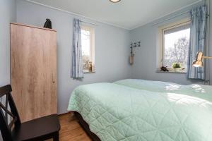 a bedroom with a green bed and two windows at Christoffellaan 57 in Brouwershaven