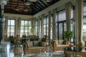 a lobby with chairs and tables and windows at Seashell Samssara Havelock in Havelock Island
