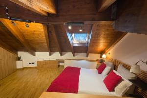 a bedroom with a large white bed with red pillows at Attico e super attico panoramico in Rocca di Cambio