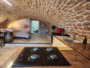a kitchen with a stone wall and a stove top oven at Gîte de Burgy in Burgy