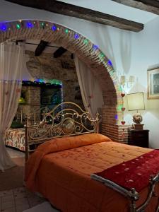a bedroom with a bed with an arch with lights at AL CANTINONE in Toffia