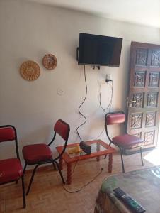 a living room with chairs and a flat screen tv at Cabañas los Materos 3 in Santa María