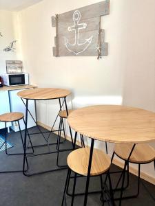 two tables and stools in a room with an anchor on the wall at Le Gouvernail - Montélimar in Montélimar