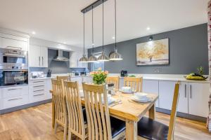 a kitchen and dining room with a wooden table and chairs at 4 Bed in Winnards Perch oc-w34023 in Saint Columb Major
