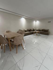 a living room with a couch and a table and chairs at Familyconfort oujda in Oujda