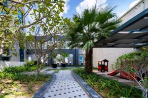a courtyard with a palm tree and a building at Vogue Vacation Homes, Business Bay Damac Cour Jardin close to Downtown, Burj Khalifa and Dubai Mall, Studio Apartment with City View, Access to all Amenities in Dubai