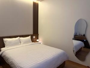 a bedroom with a white bed and a mirror at 19 home in Hue